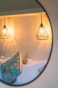 a mirror reflecting a bed with a pillow and lights at Gili Divers Hotel in Gili Trawangan