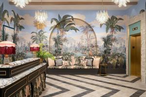 a lobby with a mural of palm trees and a couch at The Goodtime Hotel, Miami Beach a Tribute Portfolio Hotel in Miami Beach