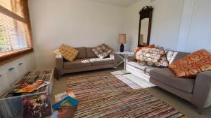 ein Wohnzimmer mit 2 Sofas und einem Teppich in der Unterkunft Sisters Beach House in Sisters Beach