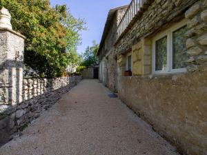 eine Gasse mit einer Steinmauer neben einem Gebäude in der Unterkunft Gîte Naussannes, 2 pièces, 2 personnes - FR-1-616-194 in Naussannes