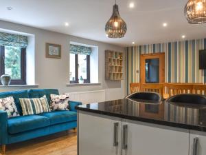 a kitchen and living room with a blue couch at Larpool Mews in Whitby
