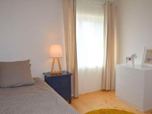 ein Schlafzimmer mit einem Bett und einer Lampe auf einem Nachttisch in der Unterkunft Gîte Coulonges, 4 pièces, 6 personnes - FR-1-653-127 in Coulonges