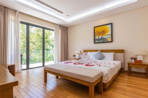 ein Schlafzimmer mit einem großen Bett mit Blumen darauf in der Unterkunft Villas Owner in The Ocean Resort Da Nang in Đà Nẵng