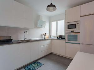 a white kitchen with white cabinets and a sink at Bel appartement rénové, calme, proche centre et plage, balcon, 2 chambres, commerces à 150m - FR-1-4-685 in Saint-Jean-de-Luz +14 photos