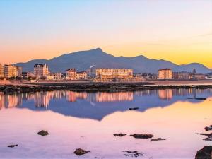 a view of a city with mountains in the background at Bel appartement rénové, calme, proche centre et plage, balcon, 2 chambres, commerces à 150m - FR-1-4-685 in Saint-Jean-de-Luz