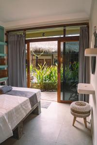 a bedroom with a bed and a sliding glass door at Gili Divers Hotel in Gili Trawangan