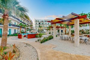 un patio con mesas y sillas y un edificio en Torres San Jose C25, en San José del Cabo