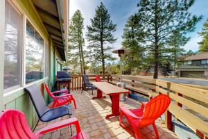 a patio with colorful chairs and a wooden table at Caribou Cabin in Munds Park