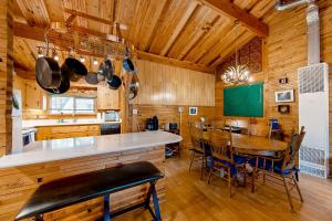 a kitchen with wooden walls and a table and chairs at Caribou Cabin in Munds Park
