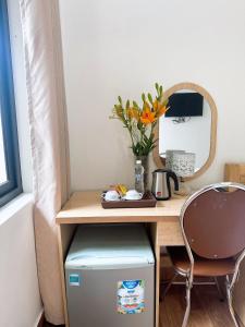 een bureau met een spiegel en een tafel met een stoel bij GOLDEN LAND HOTEL in Cat Ba