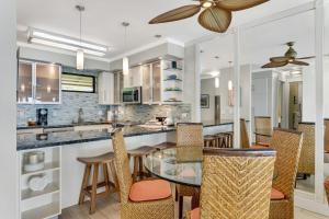 a kitchen with a glass table and chairs at Poipu Shores 403A in Koloa