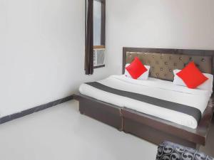 um quarto com uma cama com duas almofadas vermelhas em Super OYO Flagship GRANDEUR HOTEL em Indirapuram