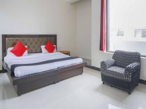 um quarto com uma cama e uma cadeira em Super OYO Flagship GRANDEUR HOTEL em Indirapuram