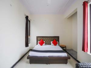 a bedroom with a bed with red pillows on it at Hotel O GRANDEUR HOTEL in Indirapuram