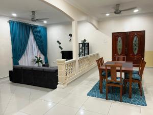 een woonkamer met een tafel en een bank bij Mutiara Villa Homestay - Comfort Away From Home in Merlimau