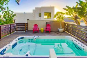 a hot tub on a deck with two pink chairs at Sunset Cliffs Modern Luxury Estate w Ocean Views, Oversized Spa, AC, Yard! in San Diego