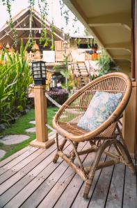 una silla de mimbre sentada en una terraza de madera en Gili Divers Hotel, en Gili Trawangan