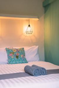 1 cama con almohada y 2 toallas en Gili Divers Hotel, en Gili Trawangan