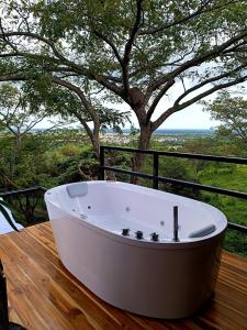 a bath tub sitting on a wooden table with a tree at Tree House Glamping in Yopal