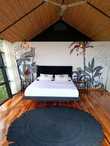 Un dormitorio con una cama con dos gatos. en Tree House Glamping, en Yopal