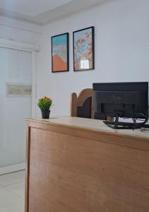 a desk with a computer monitor on top of it at ARIMBI GUEST HOUSE in Batu