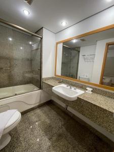 a bathroom with a sink and a toilet and a mirror at Studio Living Quality Jardins in Sao Paulo