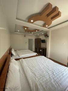 een slaapkamer met 2 bedden en een plafond bij Khách sạn Trung Hiếu in áº¤p VÄ©nh ÃÃ´ng