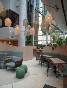 a restaurant with chairs and tables and chandeliers at Studio Living Quality Jardins in Sao Paulo
