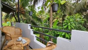 a balcony with a table and chairs and palm trees at E Seven House in Dickwella