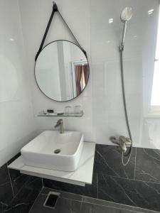 uma casa de banho branca com um lavatório e um espelho em Khách sạn Trung Hiếu em áº¤p VÄ©nh ÃÃ´ng