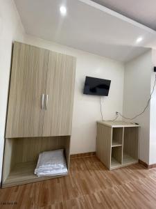 um quarto com um armário, uma televisão e uma secretária em Khách sạn Trung Hiếu em áº¤p VÄ©nh ÃÃ´ng