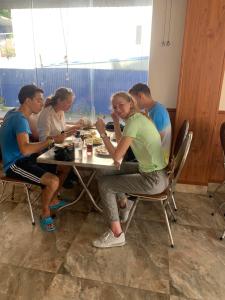 een groep mensen die aan een tafel eten bij GOLDEN LAND HOTEL in Cat Ba