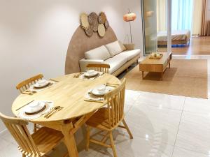 - un salon avec une table et des chaises en bois dans l'établissement Lila Suites Quill Residences Klcc, à Kuala Lumpur