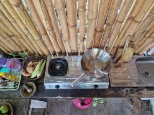 un piano cottura con una padella e del cibo di Legend guest house a Kelimutu