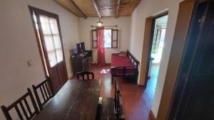 um quarto com uma mesa de madeira e cadeiras num quarto em Cabañas Tierra Andina em Tilcara