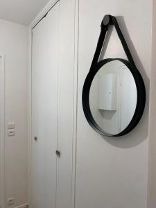 un espejo colgado en una pared junto a un armario en Luxsuite, en Aubervilliers