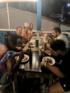un grupo de personas sentadas alrededor de una mesa comiendo comida en Rum punch lodge en Corozal