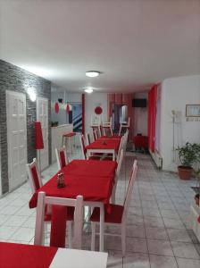 プライドにあるZoltán & Erika Panzió Parajdの赤いテーブルと白い椅子が備わるダイニングルーム