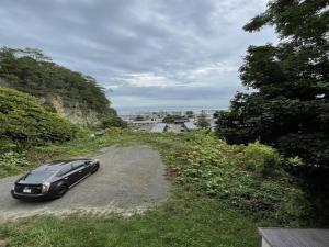 une voiture noire garée sur un chemin de terre dans l'établissement Otaru - House - Vacation STAY 15278, à Otaru