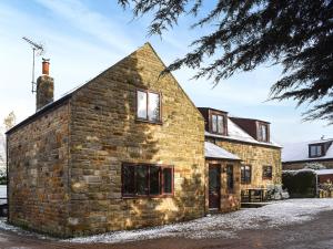 ein altes Steinhaus im Schnee in der Unterkunft Larpool Mews in Whitby