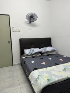 ein Schlafzimmer mit einem Bett und einem Ventilator an der Wand in der Unterkunft Paddy View Homestay Kangar in Kangar