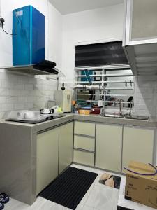 a kitchen with white cabinets and blue cabinetsigunigunigunigunigunigunigunigun at Paddy View Homestay Kangar in Kangar