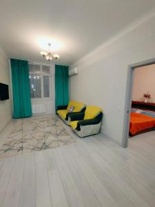a bedroom with a couch and a bed in a room at Апартаменты в ЖК Алау in Taldykolʼ