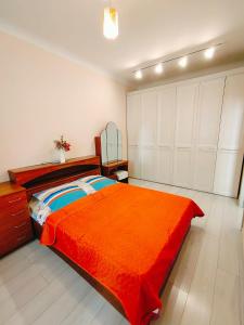 a bedroom with a large orange bed and white cabinets at Апартаменты в ЖК Алау in Taldykolʼ