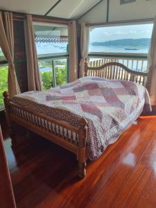 een slaapkamer met een bed en uitzicht op de oceaan bij Angel house in Ban Tha Thewawong