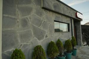 a stone building with potted plants in front of it at An Gimnyeong Stay in Jeju