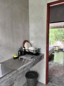a kitchen with a counter with a tray of dishes at Ngam Hidden Cabin Room in Thongsala