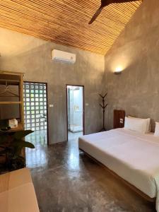 sypialnia z dużym białym łóżkiem w pokoju w obiekcie Ngam Hidden Cabin Room w mieście Thongsala