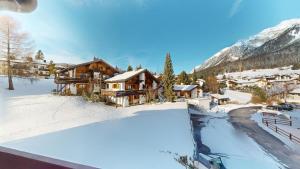a winter view of a lodge in the mountains at Family holiday home Tgiampi Sot Lantsch Lenzerheide in Lenz
