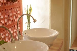 baño con lavabo blanco y ventana en Bajo Bunkhouse en Labuan Bajo